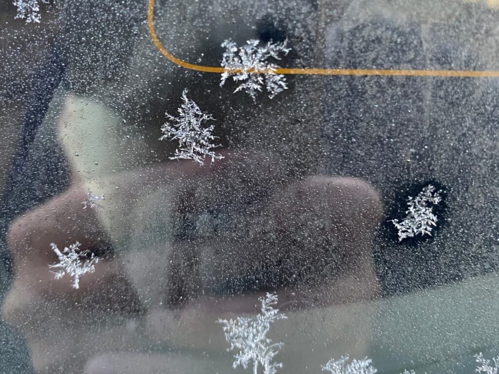 冬の朝に凍った車のフロントガラスの写真