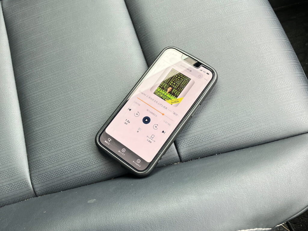 停車中の車内でAudibleを再生しているスマートフォン